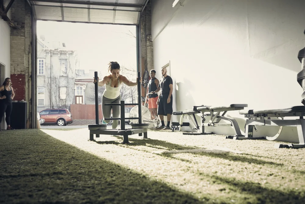 Atleta femenina haciendo sled push
